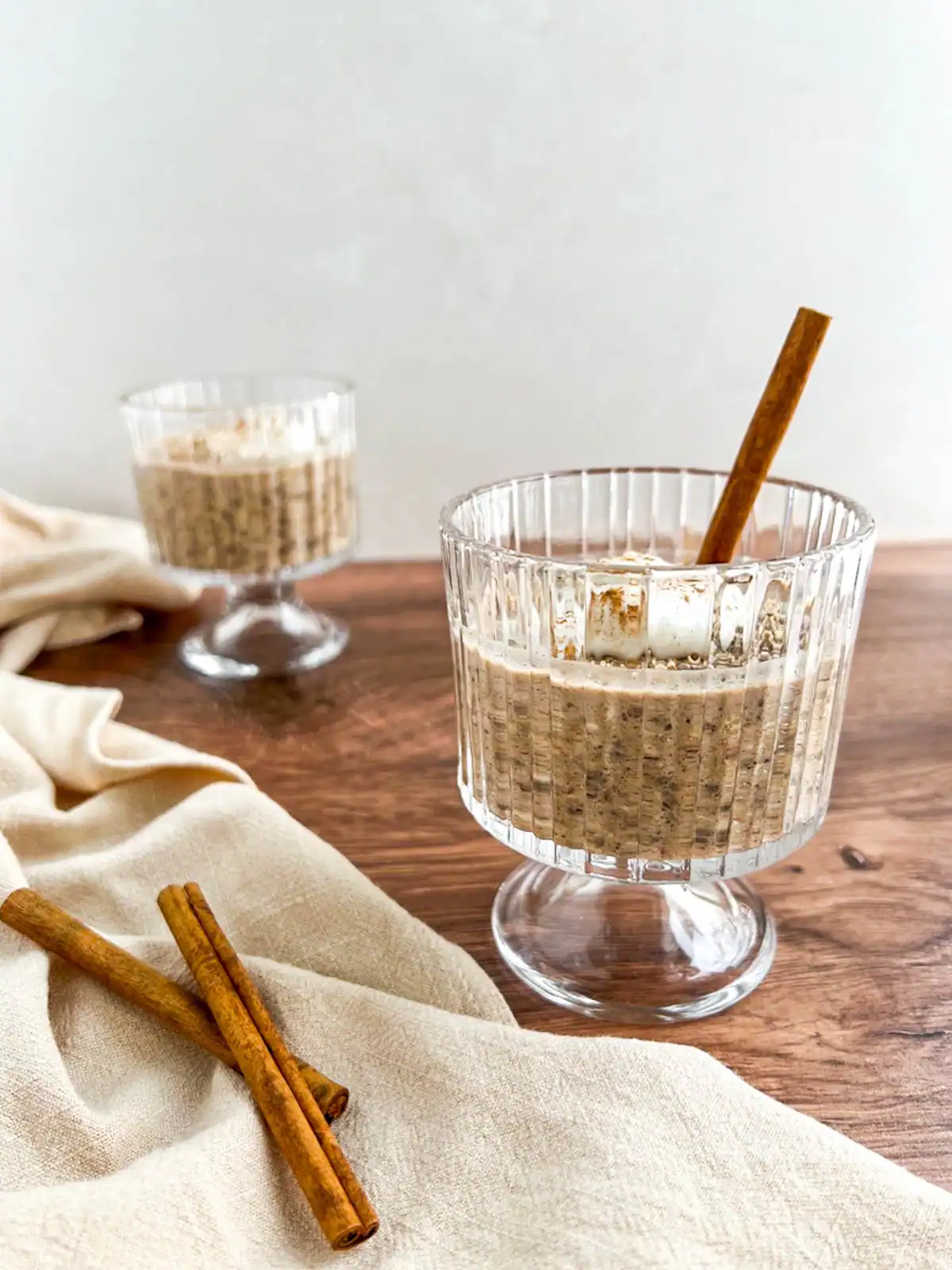 Chai spice overnight oats in elegant glassware.