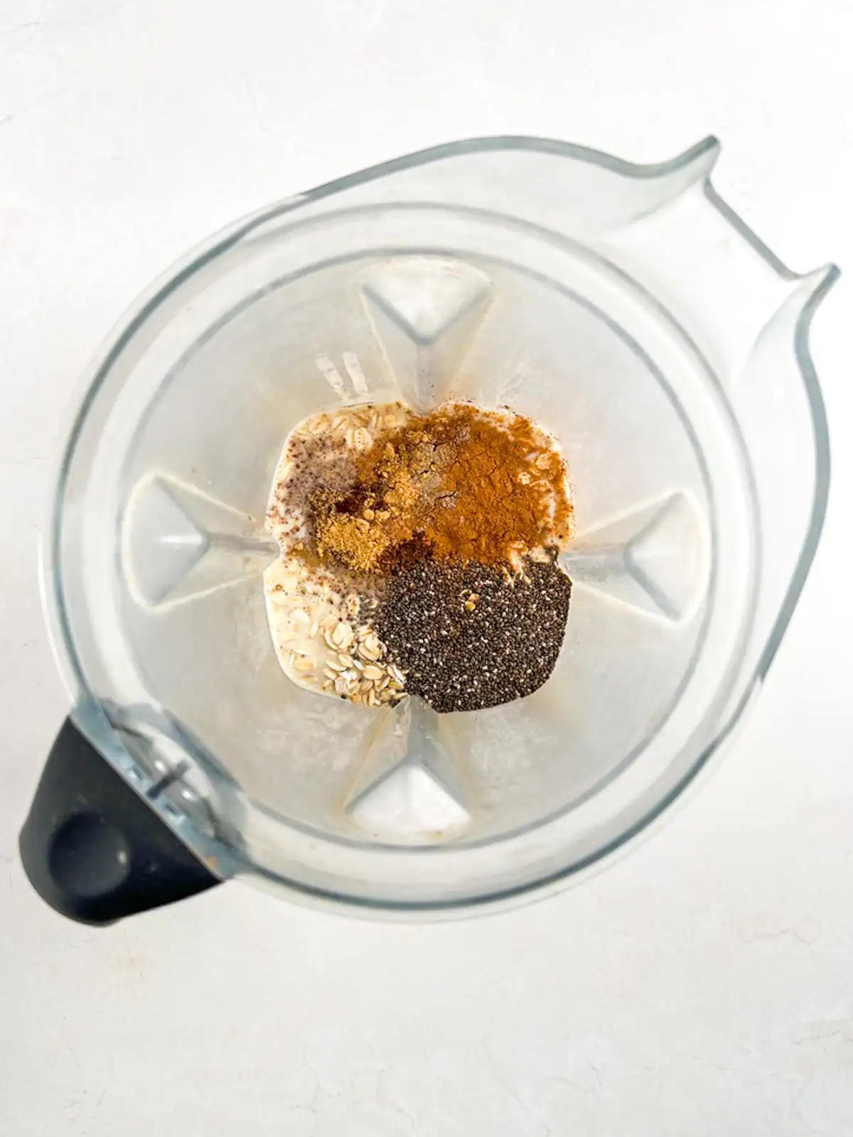 Mixed plant-based ingredients in blender for chai spice overnight oats.