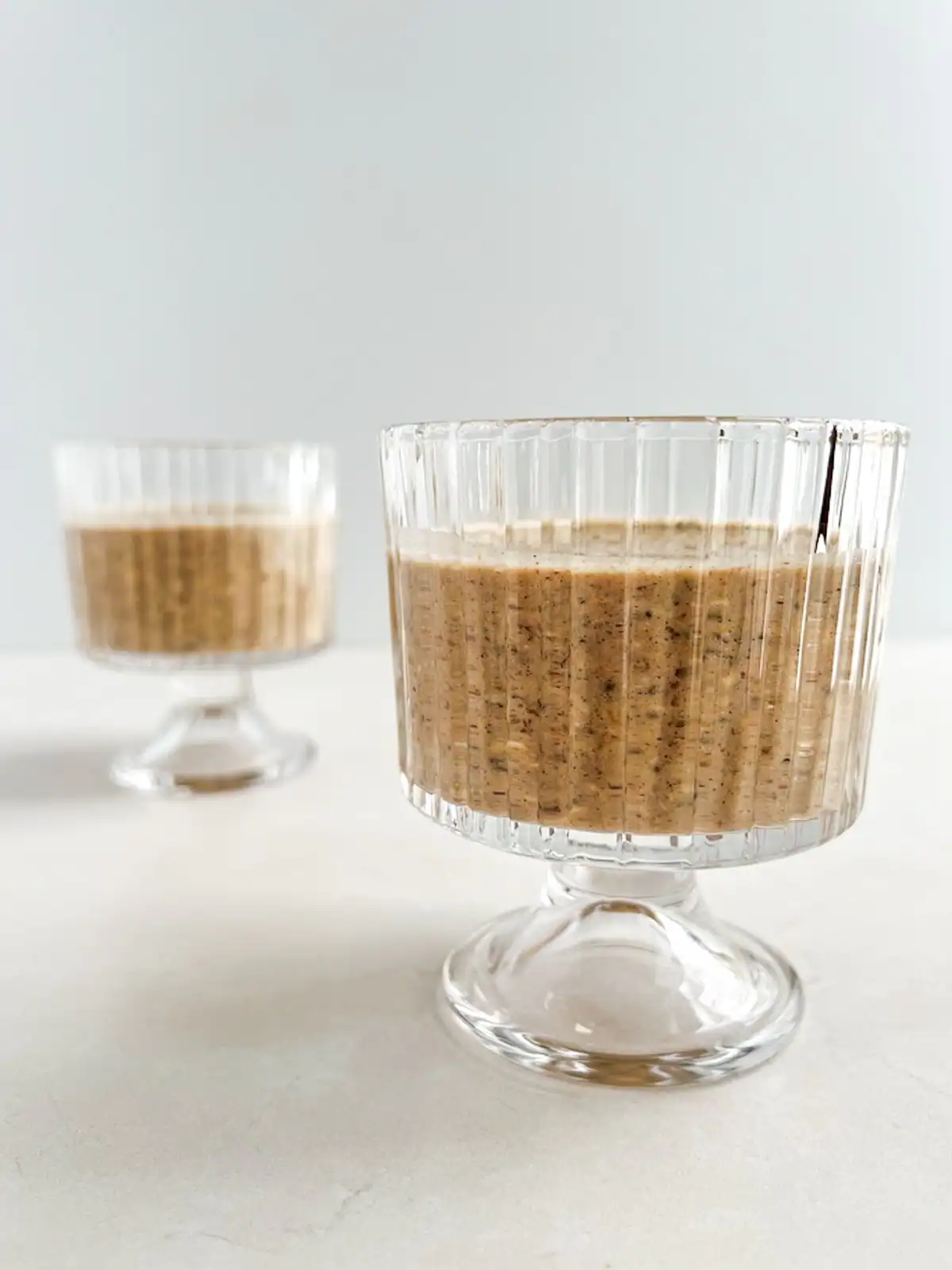 Chai spice overnight oats in vintage glasses.