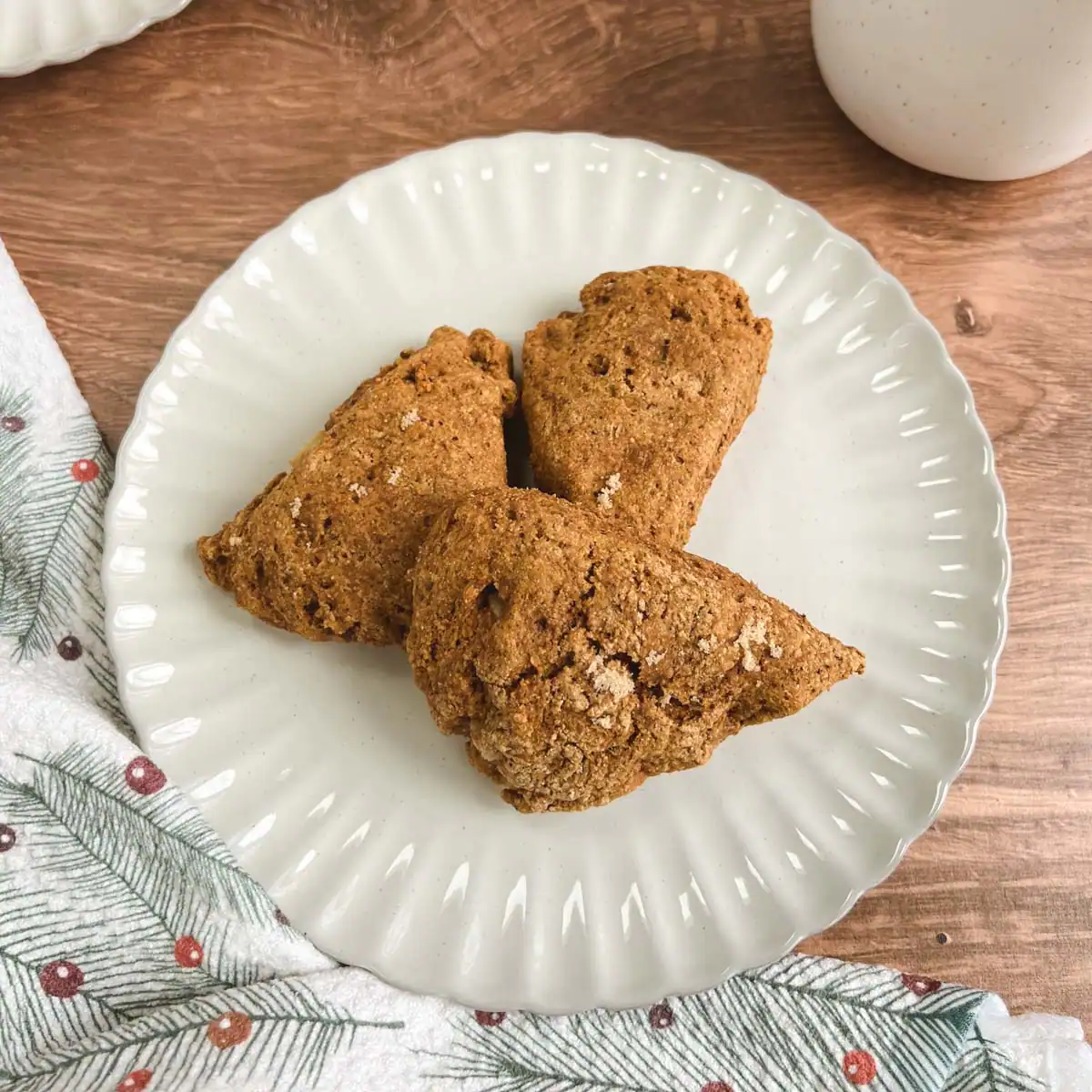 Ginger pear scones on a plate next to a festive cloth.