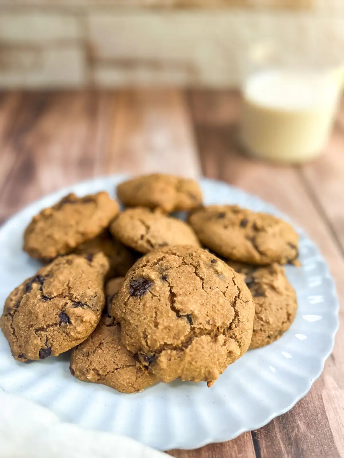 Soft and chewy gluten-free vegan chocolate chip cookies on a white plate.