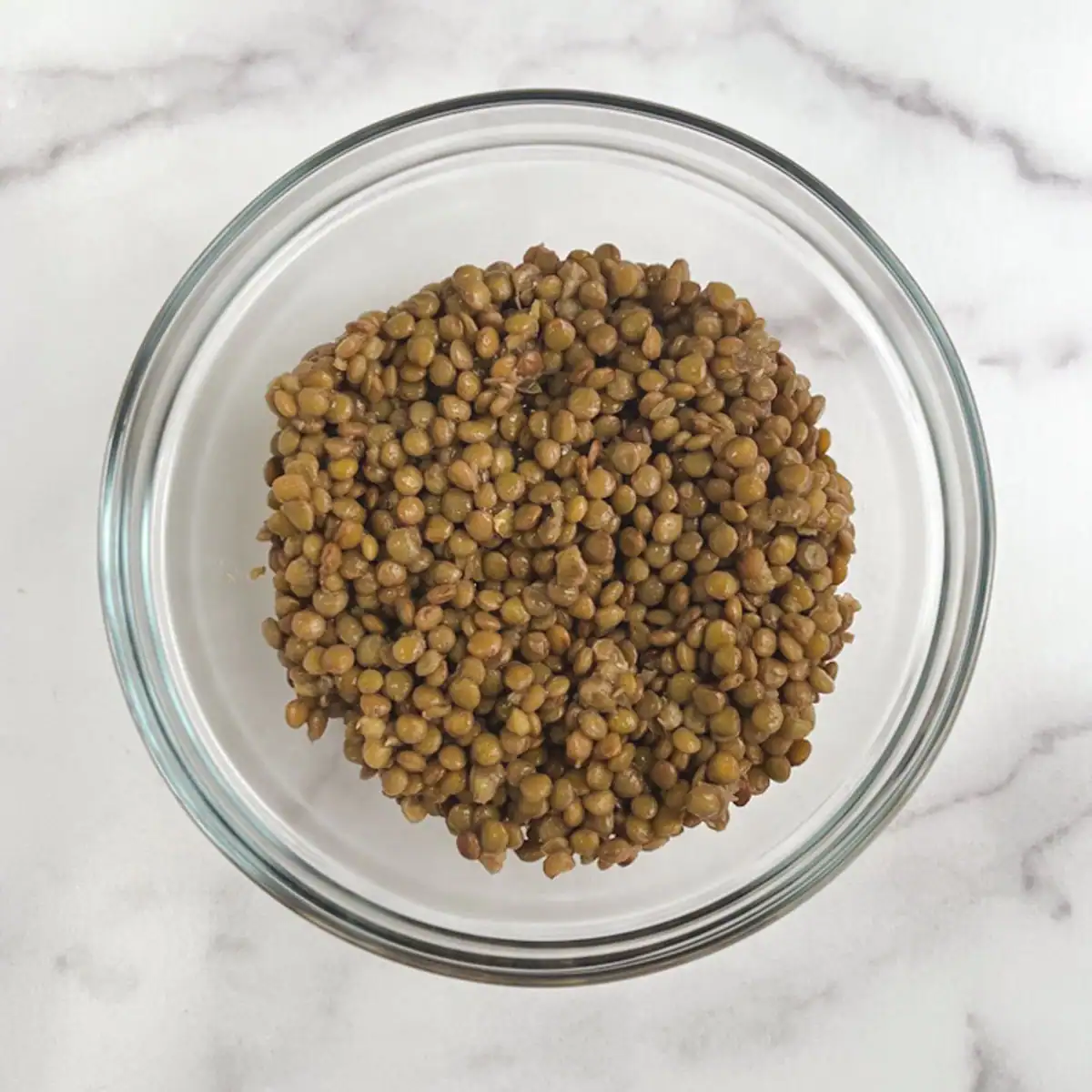 Cooked lentils in a glass bowl.