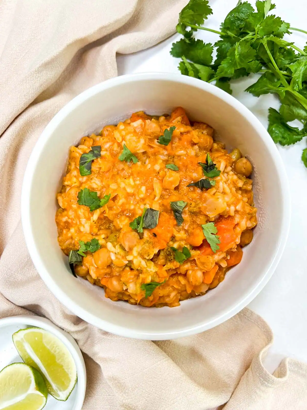 Vegan Instant Pot red curry with chickpeas and rice, garnished with fresh herbs.