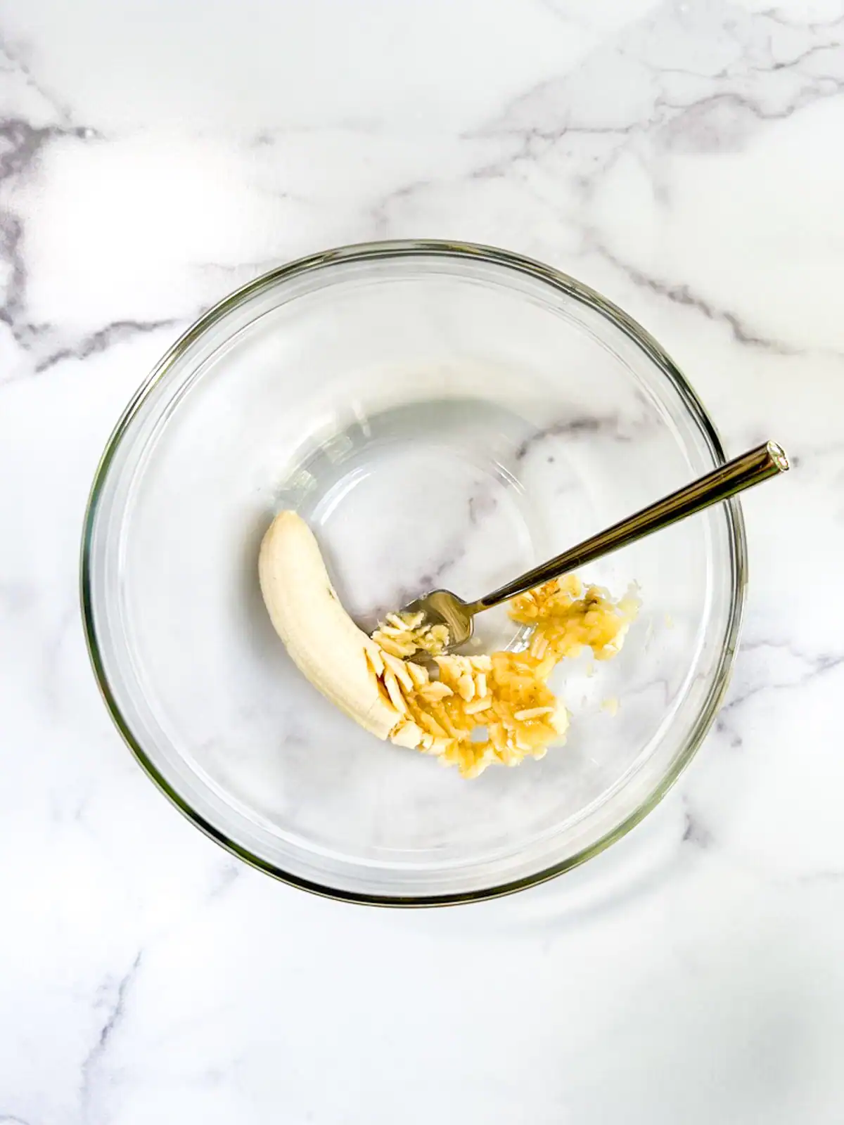 Mashed banana in a glass bowl.