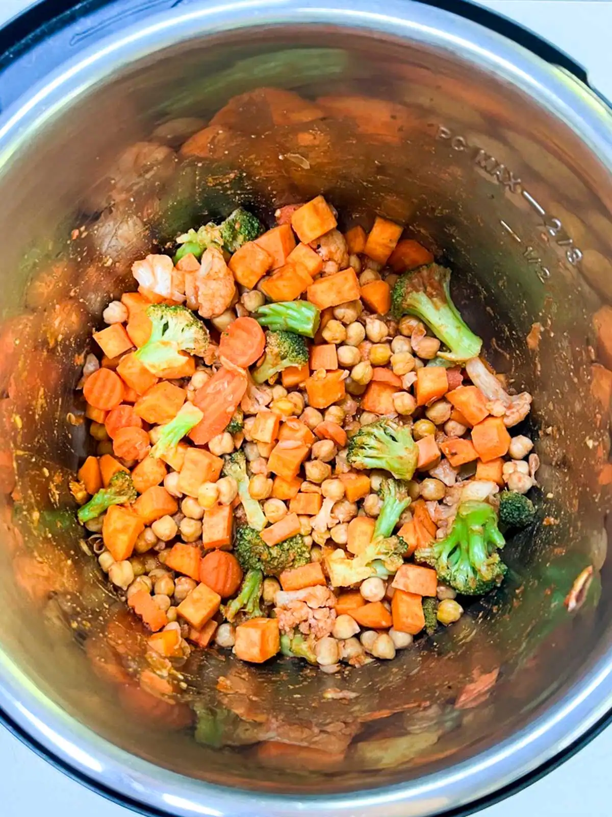Vegetables, chickpeas, and seasoning in an Instant Pot.