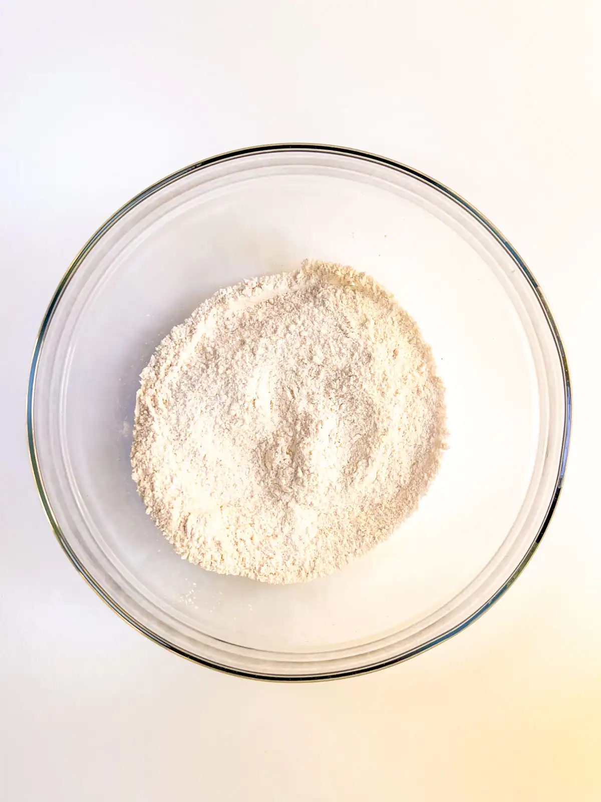 Dry ingredients for vegan orange muffins in a glass bowl.