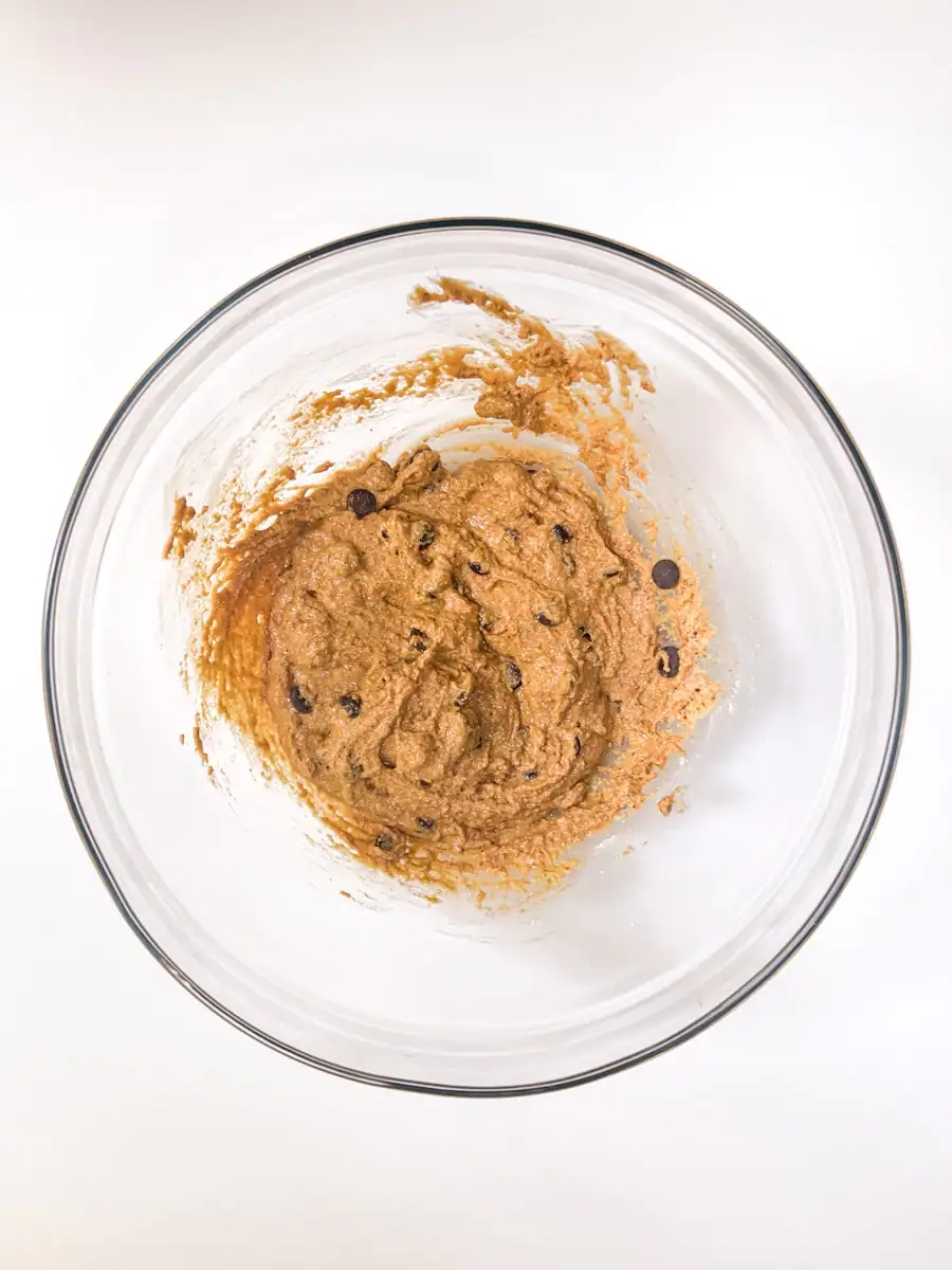 Wet ingredients for gluten-free vegan chocolate chip cookies in a glass bowl with chocolate chips added.