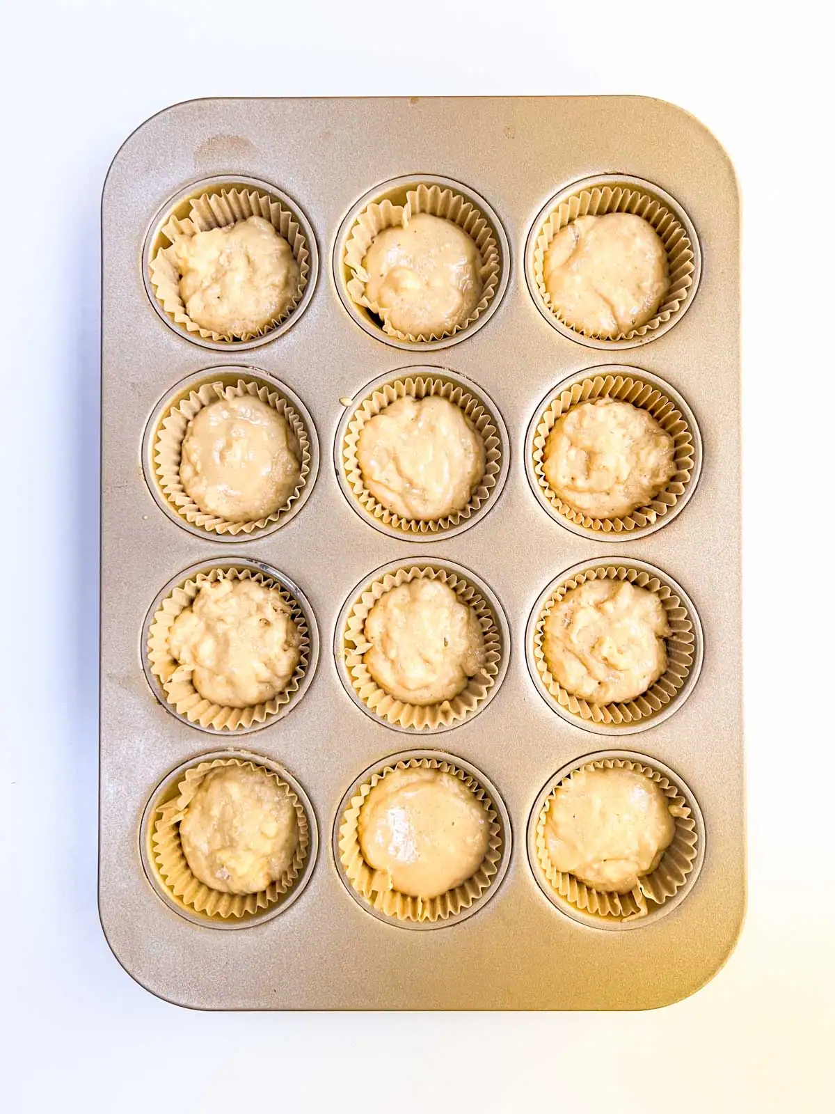 Vegan orange muffin batter in a baking tin.