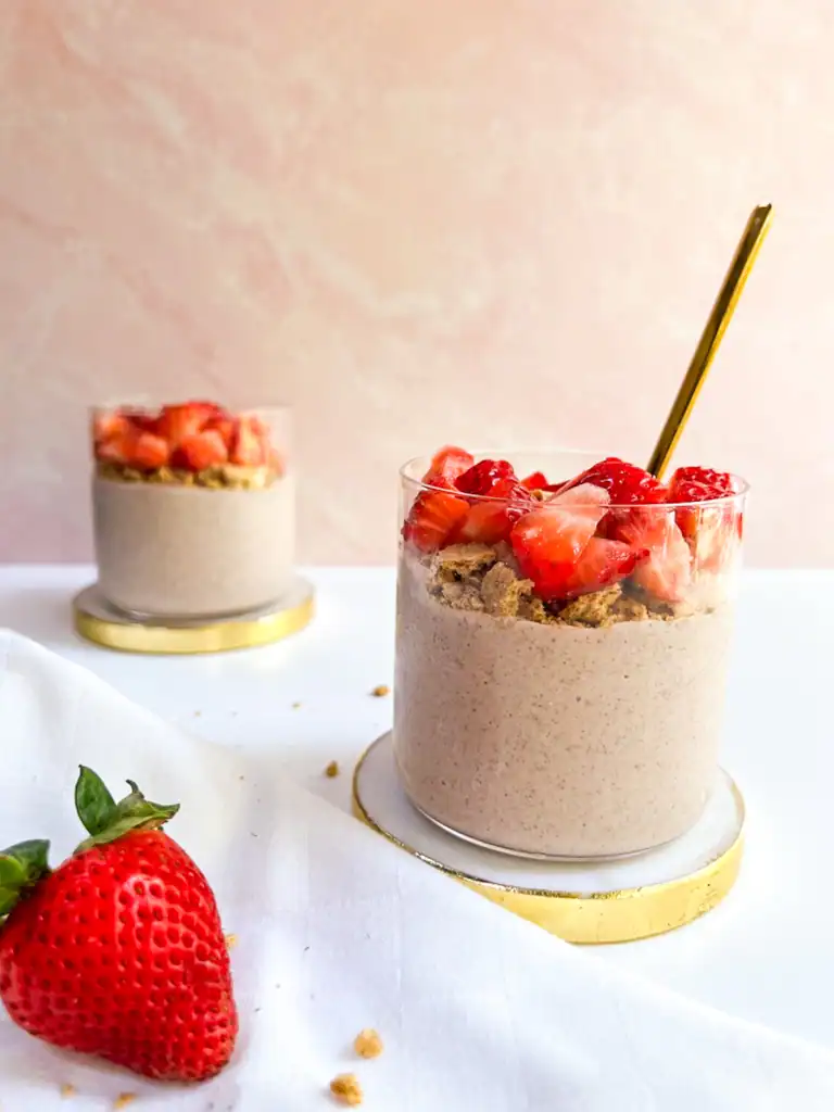 Creamy strawberry overnight oats with graham crackers in a glass.