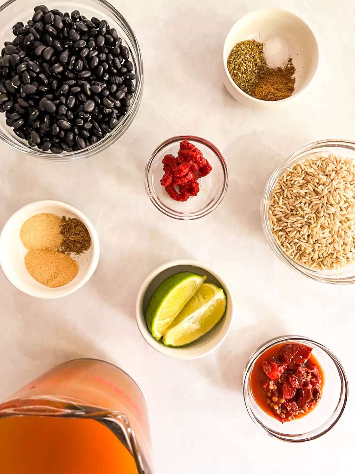 Black beans, spices, lime wedges, and other ingredients for vegan Instant Pot black beans and rice.