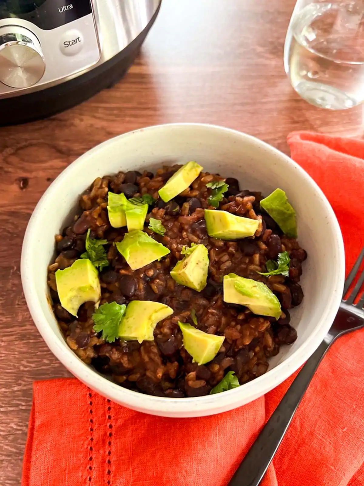 Vegan Instant Pot black bean and rice bowl with avocado and fresh cilantro.