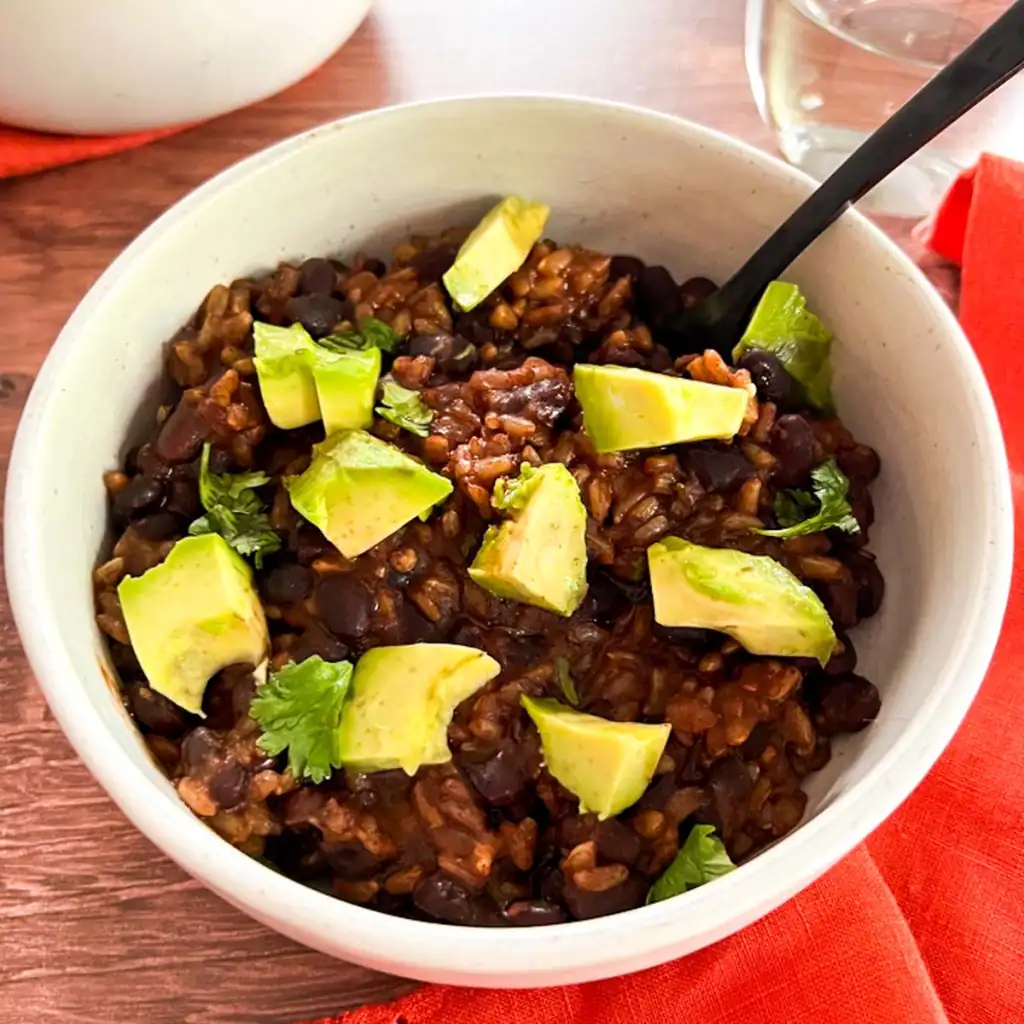 Vegan Instant Pot black bean and rice bowl with avocado and cilantro.