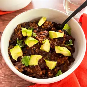 Vegan Instant Pot black bean and rice bowl with avocado and cilantro.