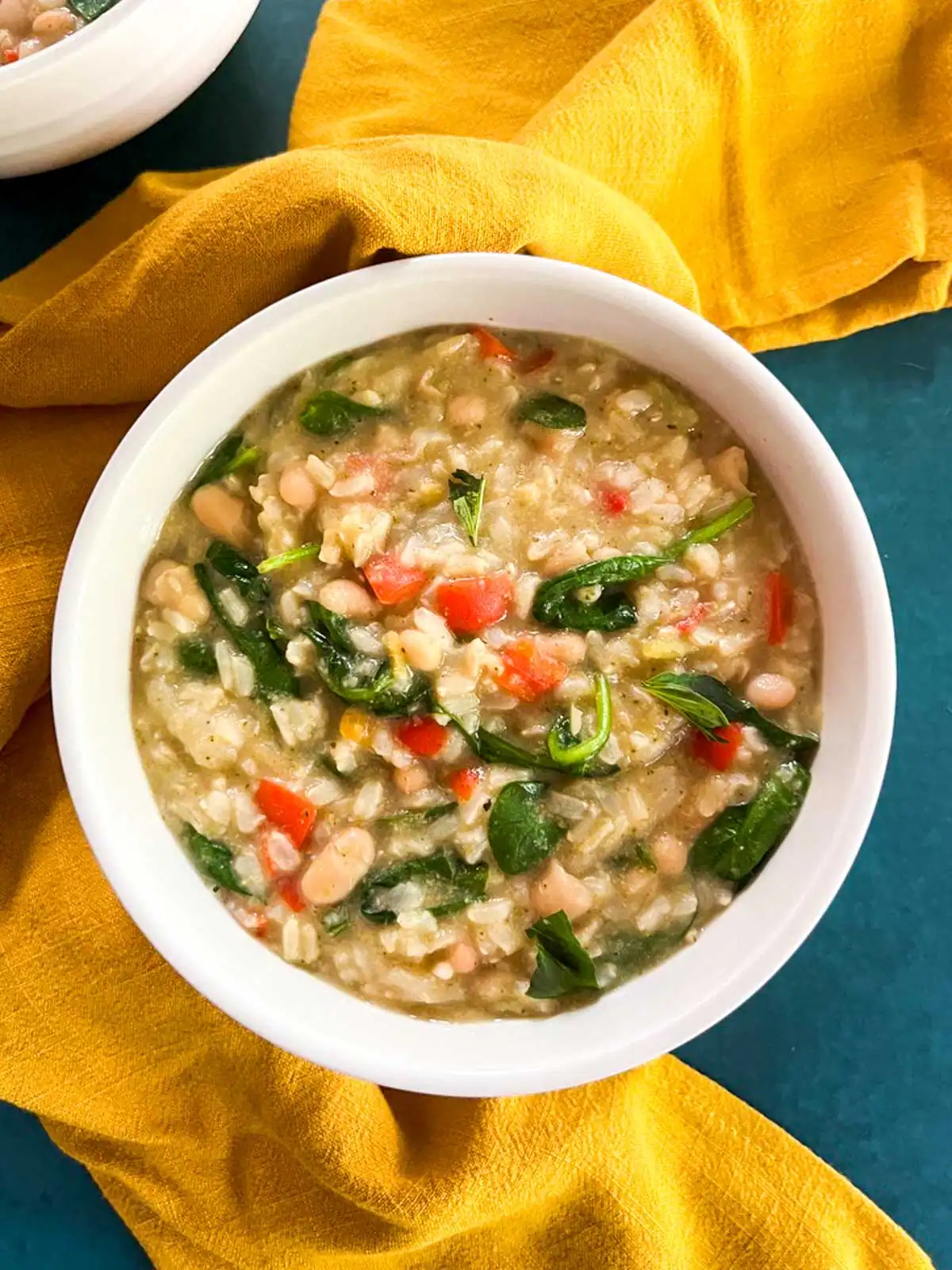 Creamy Instant Pot vegan green curry rice n a white bowl on yellow cloth.