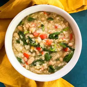 Creamy Instant Pot vegan green curry rice in a white bowl next to a yellow cloth.