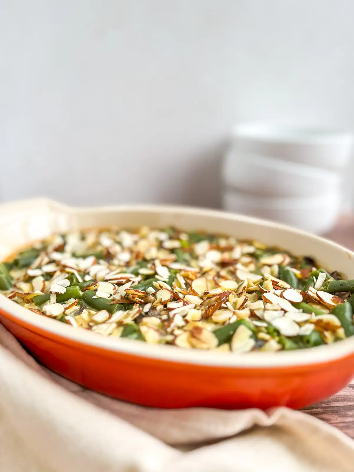 Baked vegan green bean casserole with toasted almond topping.
