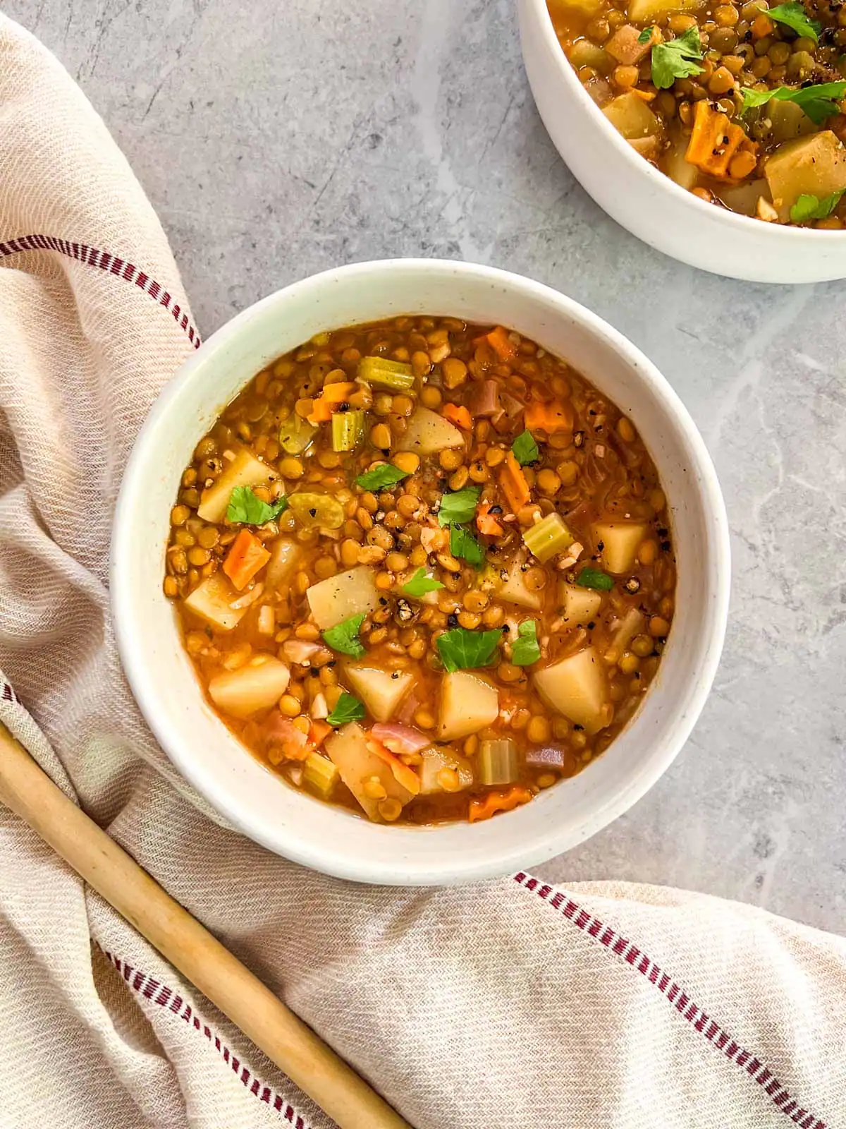 Instant Pot vegan lentil and vegetable soup in white bowl.