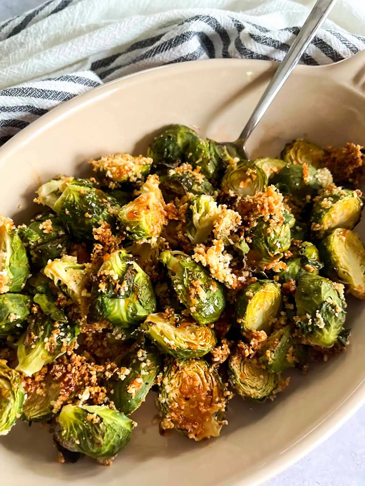 Crispy roasted Brussels sprouts with spicy maple glaze in a serving dish.