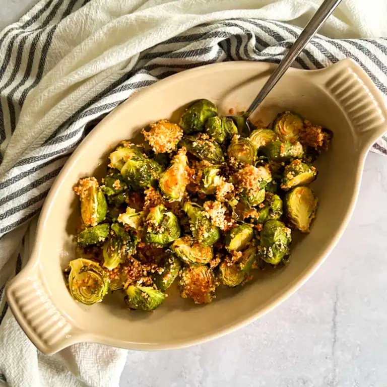 Crispy roasted Brussels sprouts topped with spicy maple glaze in a serving dish.