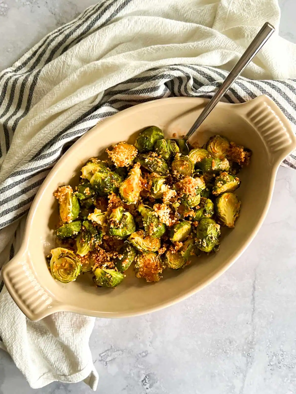 Crispy roasted Brussels sprouts topped with spicy maple glaze in a serving dish.
