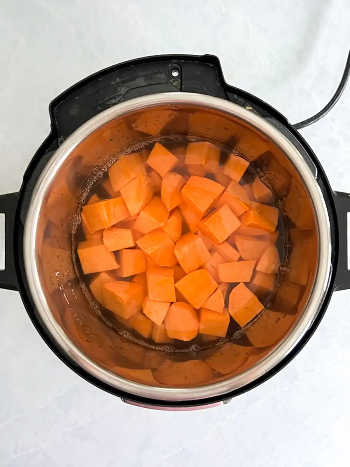 Fresh sweet potatoes in an electric pressure cooker.