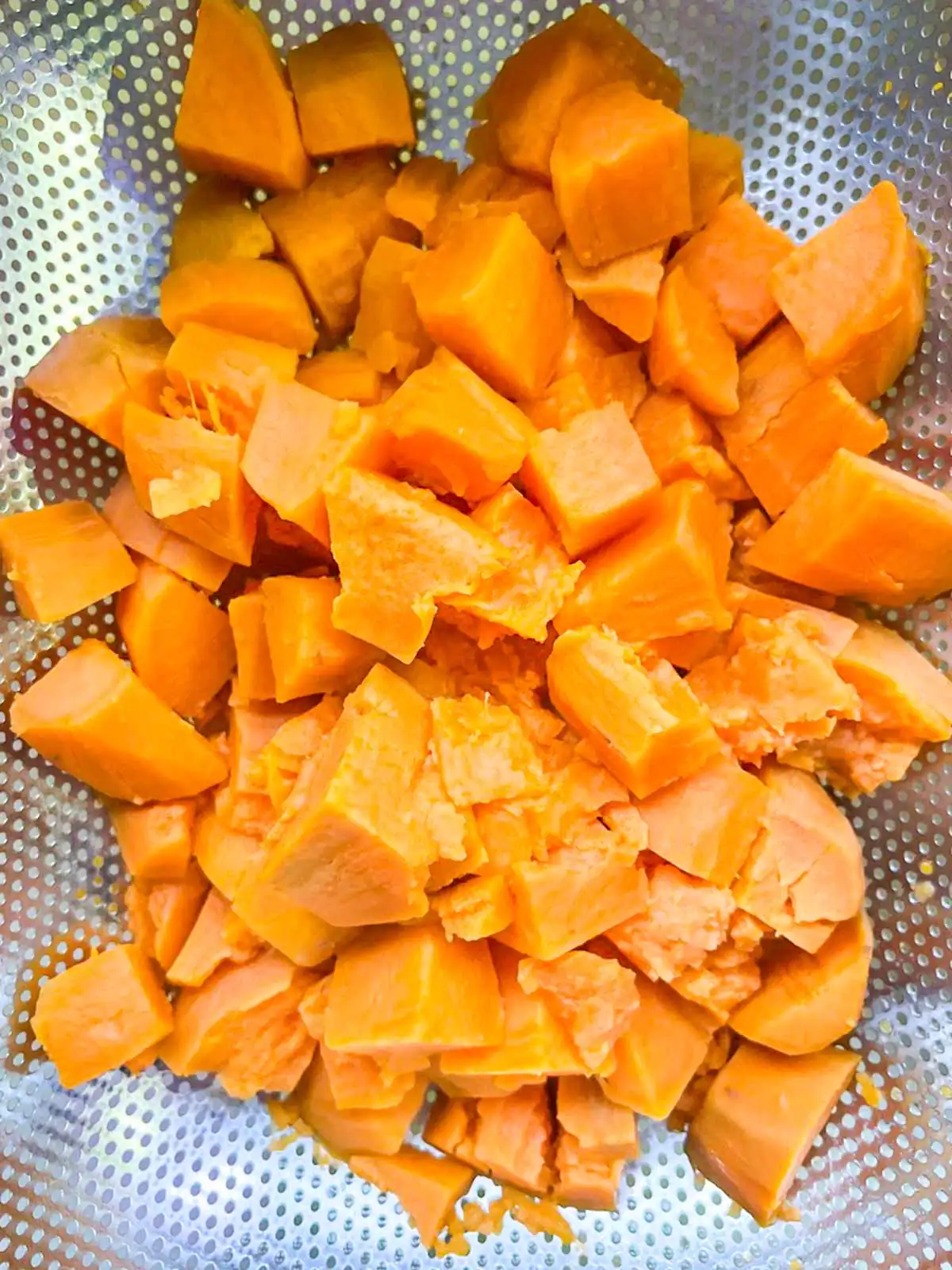 Sweet potato chunks in a colander.