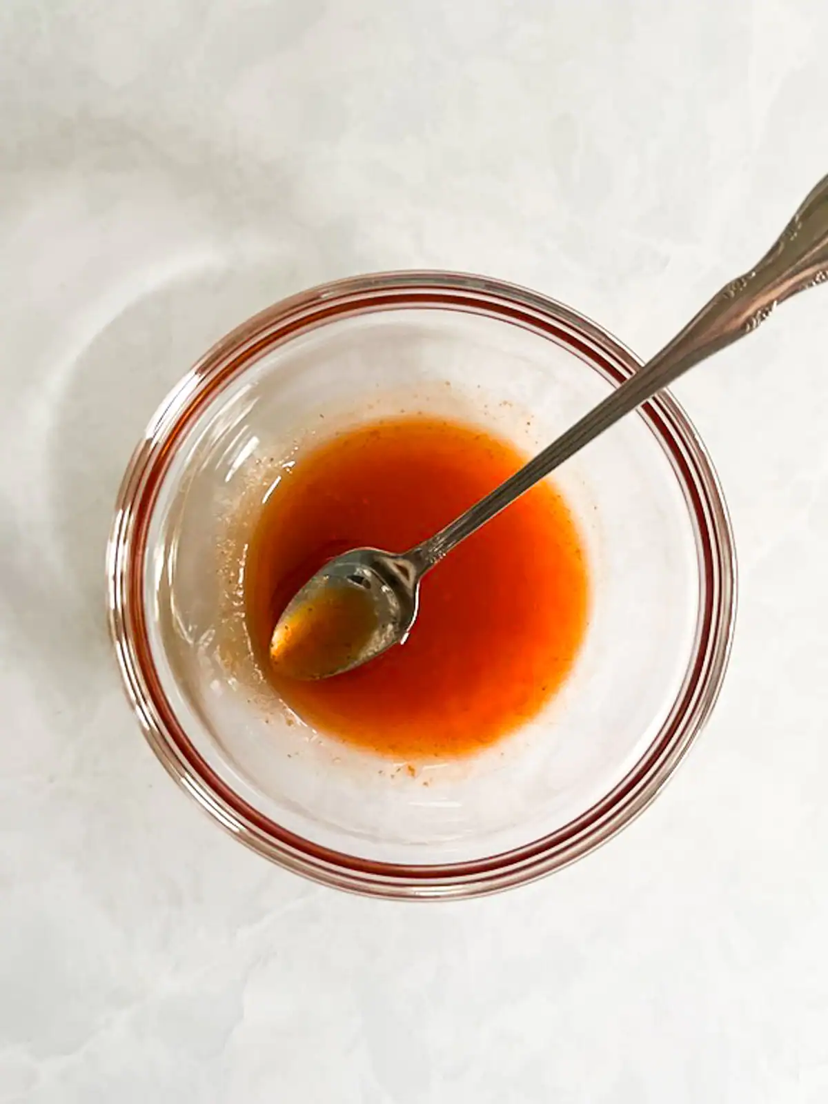 Spicy maple glaze in a glass bowl with a spoon.
