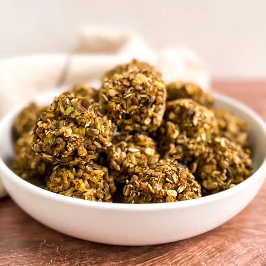 Vegan stuffing balls in a white bowl on a wooden table.