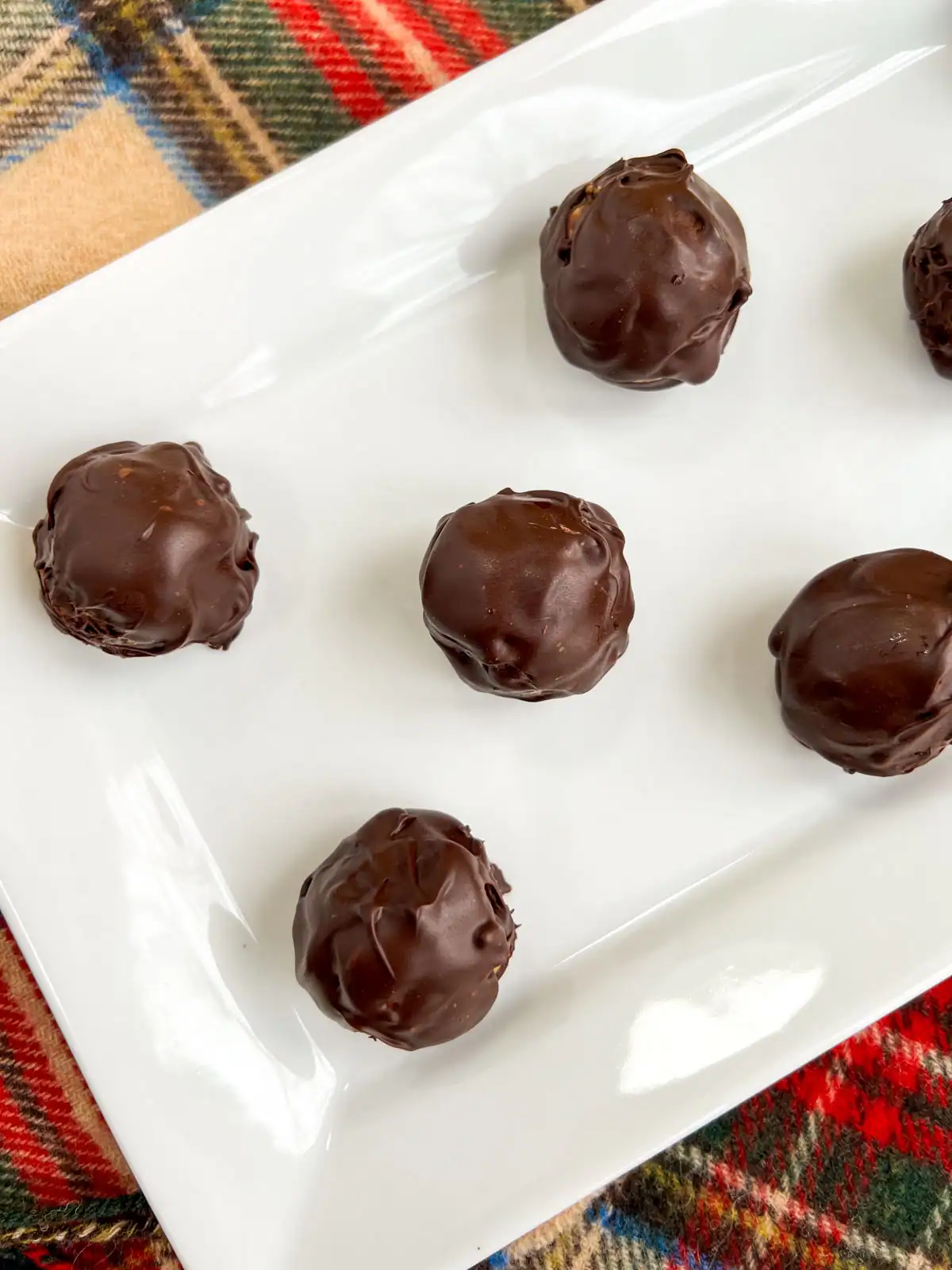 No-bake chocolate peanut butter pretzel balls on a white plate.