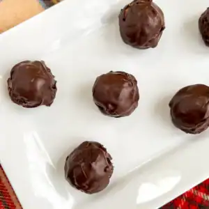 No-bake chocolate peanut butter pretzel balls on a white plate.