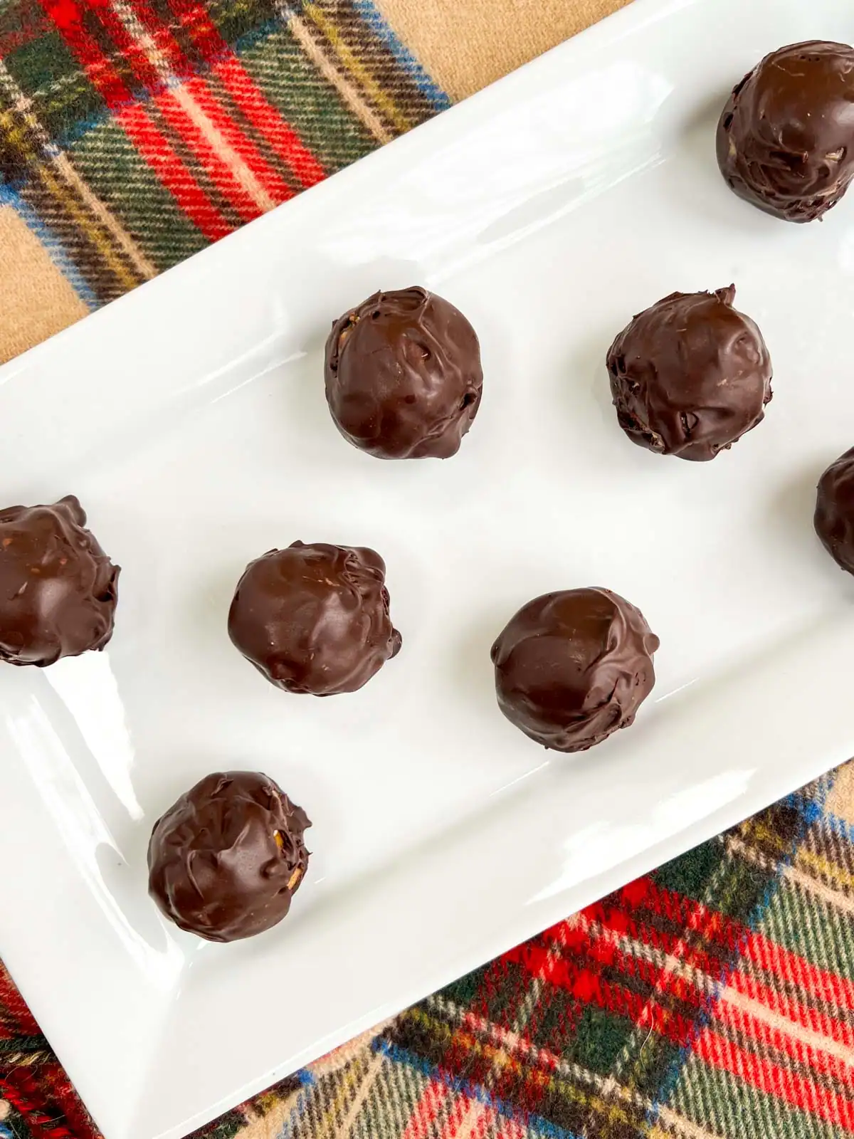 No-bake chocolate peanut butter pretzel balls on a white plate.