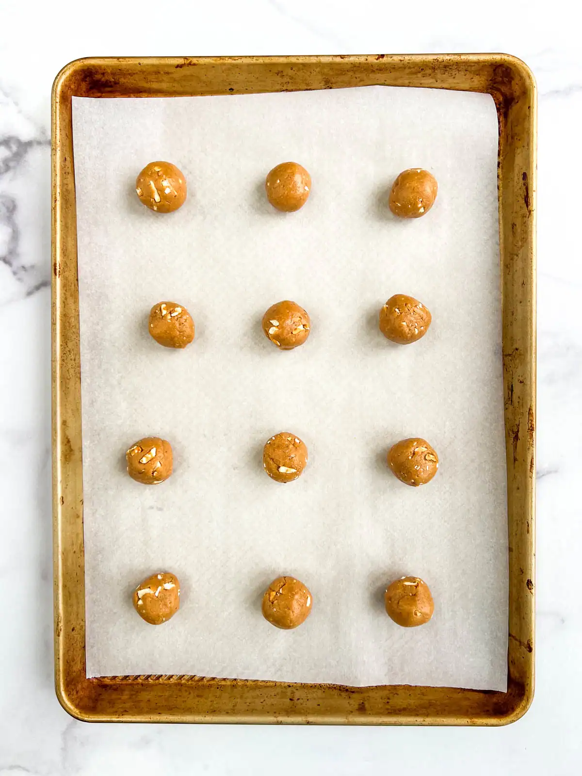 Peanut butter pretzel balls on prepared baking sheet.
