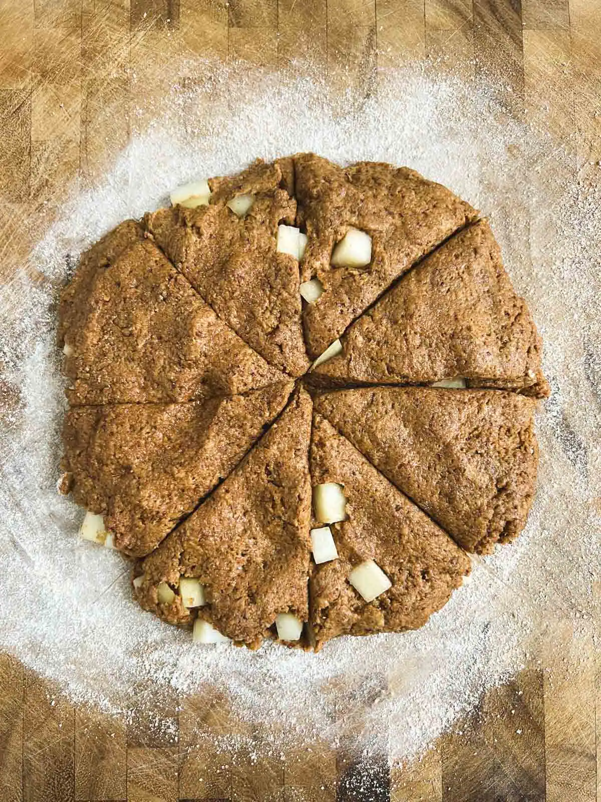 Vegan ginger pear scones cut into triangles on a cutting board.