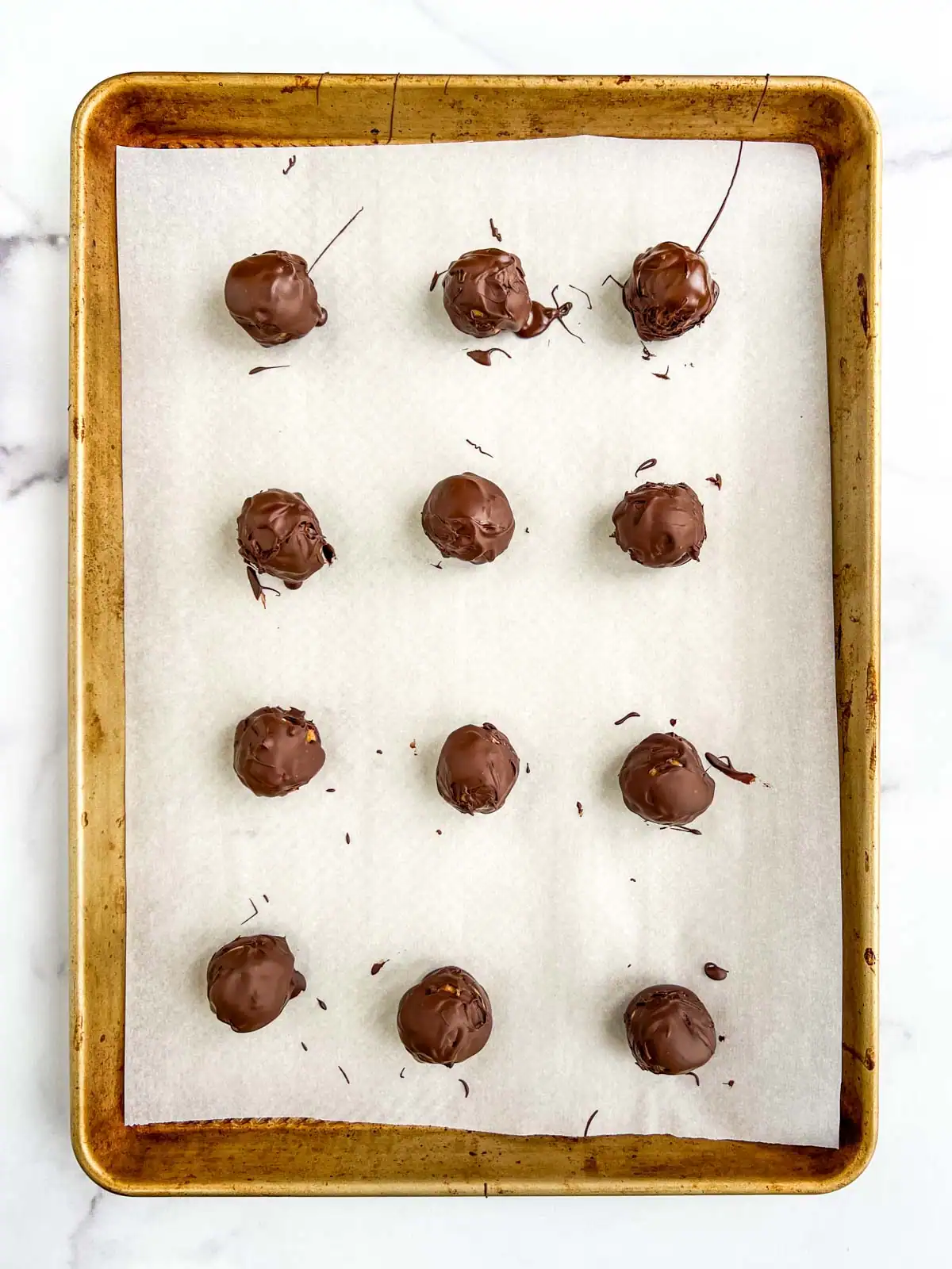 Chocolate peanut butter pretzel balls on prepared baking sheet.