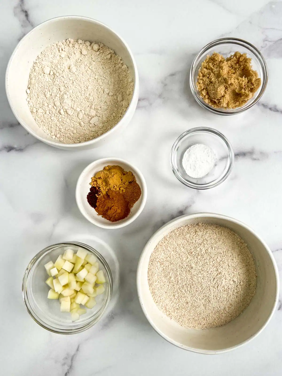 Dry ingredients for vegan ginger pear scones on a marble surface.
