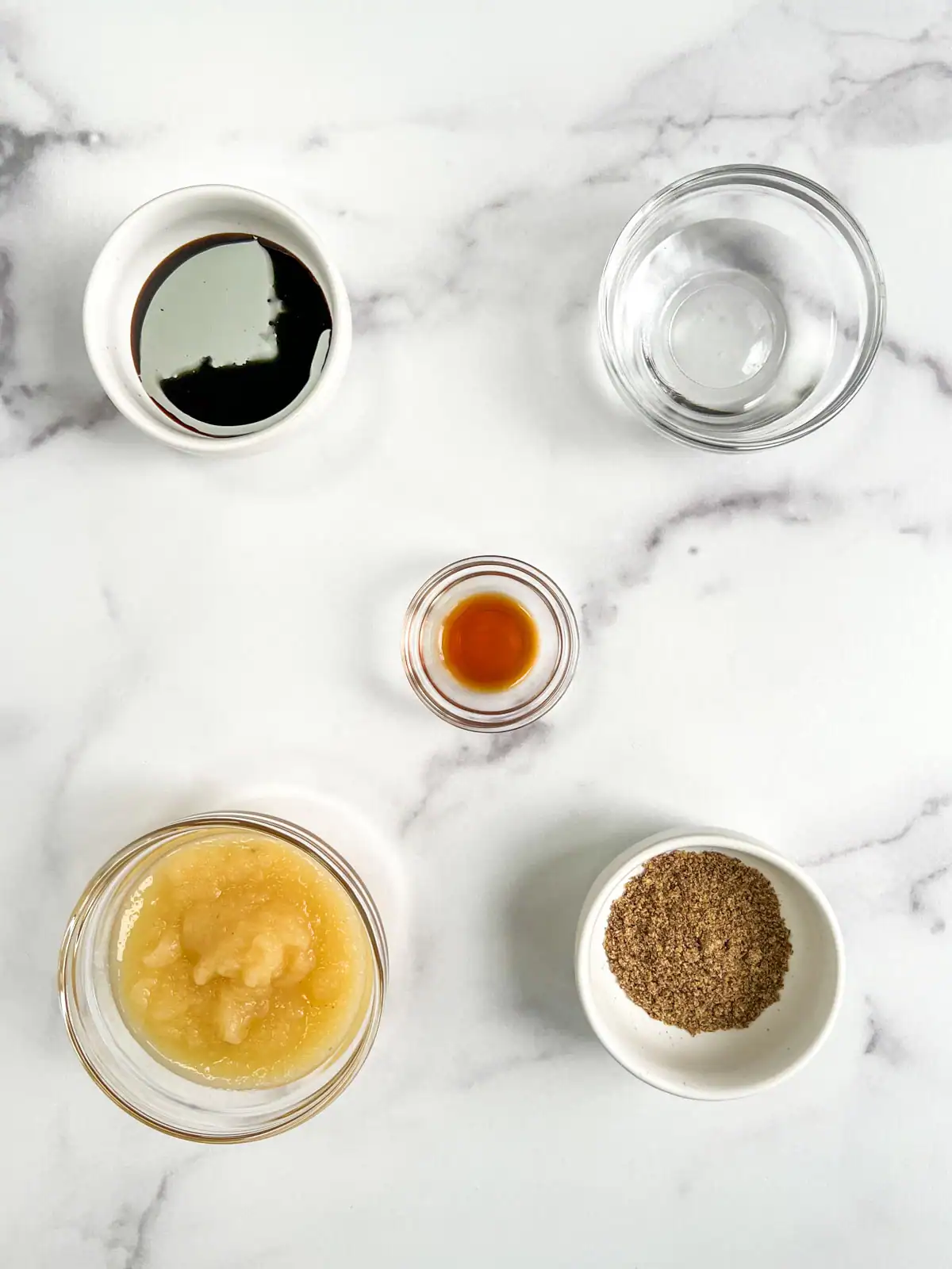 Wet ingredients for vegan ginger pear scones on a marble surface.