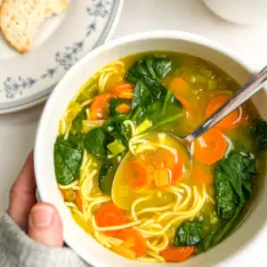 A bowl of immune-boosting vegetable soup cupped in a hand.