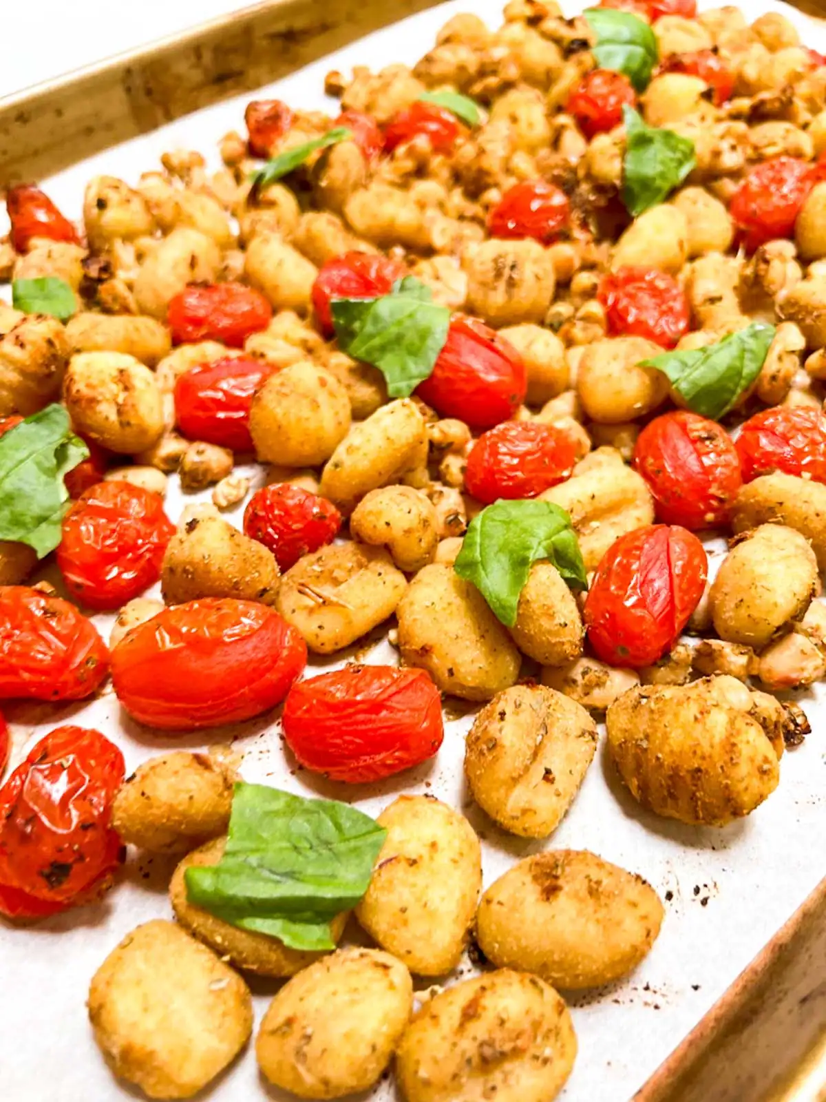 Gnocchi with blistered tomatoes and white beans on a sheet pan.