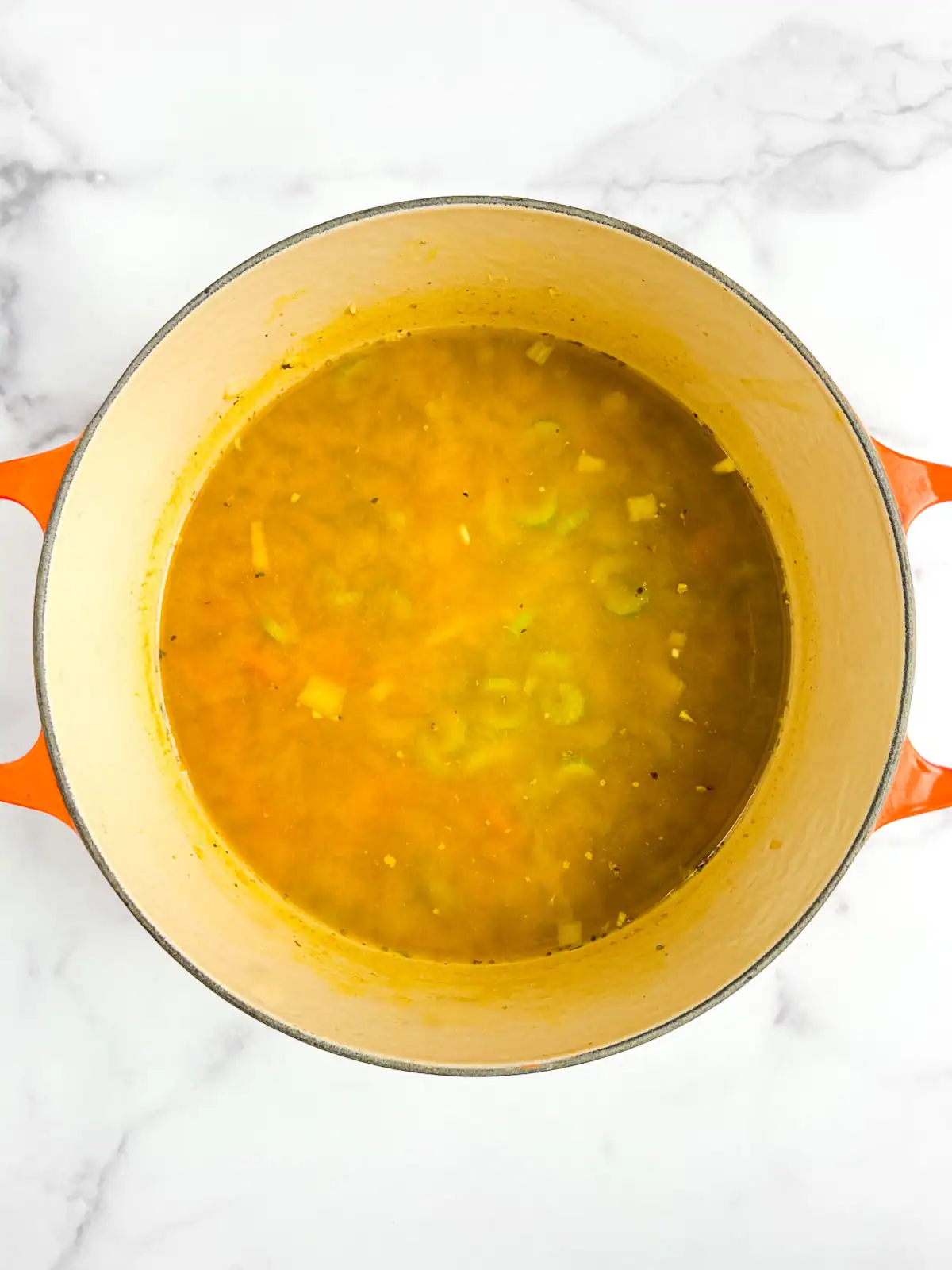 Vegetables in a Dutch oven with broth added.