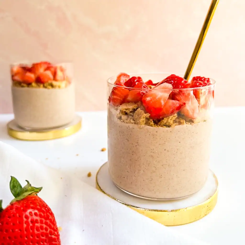 Blended strawberry overnight oats topped with fresh strawberries and graham crackers.