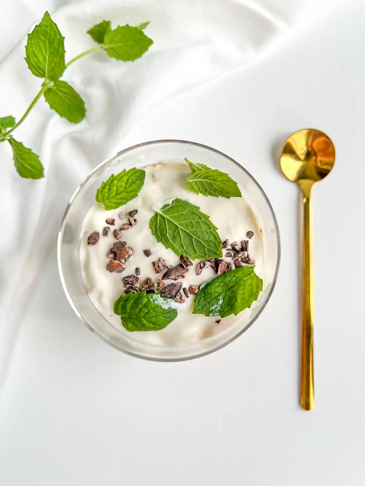 Overhead view of mint chocolate blended overnight oats and a gold spoon.