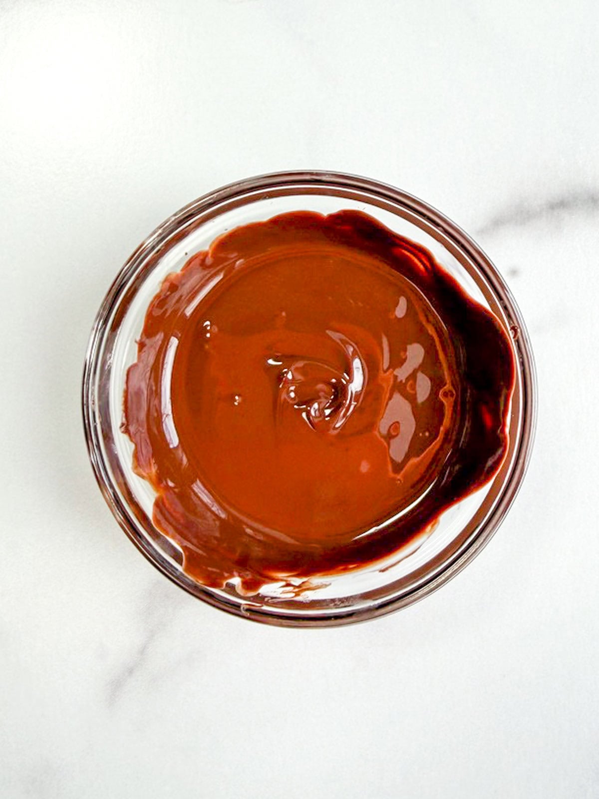 Melted chocolate in a glass bowl.