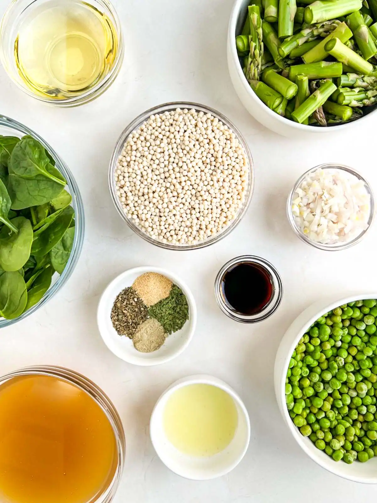 Ingredients for baked pearl couscous with asparagus and peas.