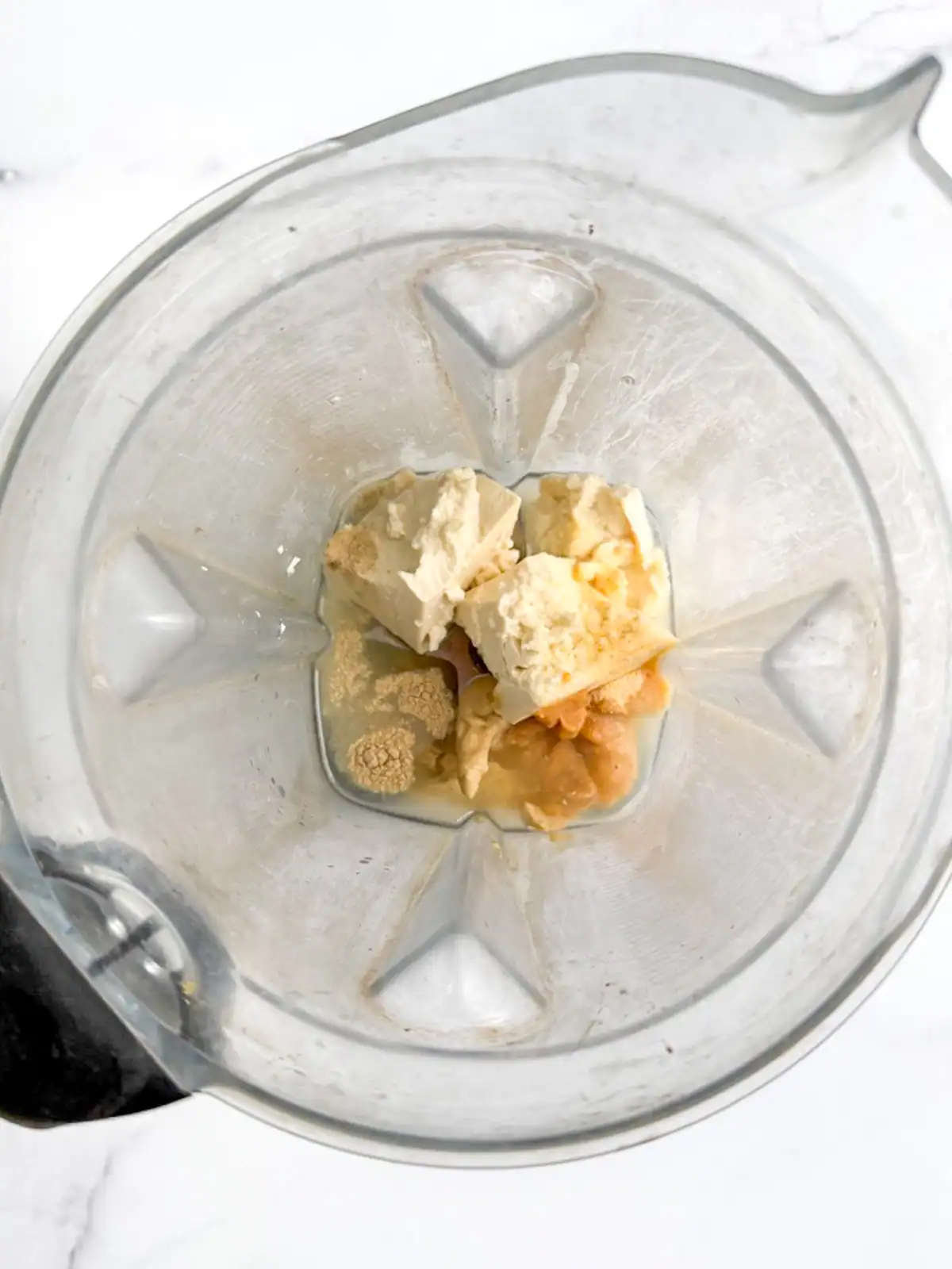 Ingredients for vegan Caesar dressing in a blender.