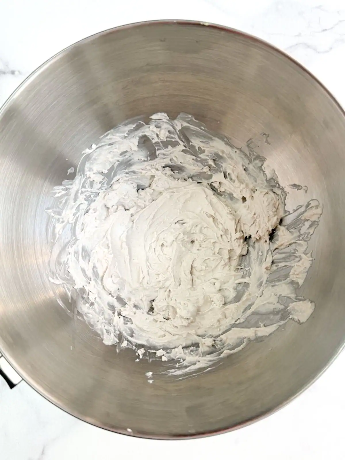 Vegan coconut whipped cream in a stainless steel bowl.