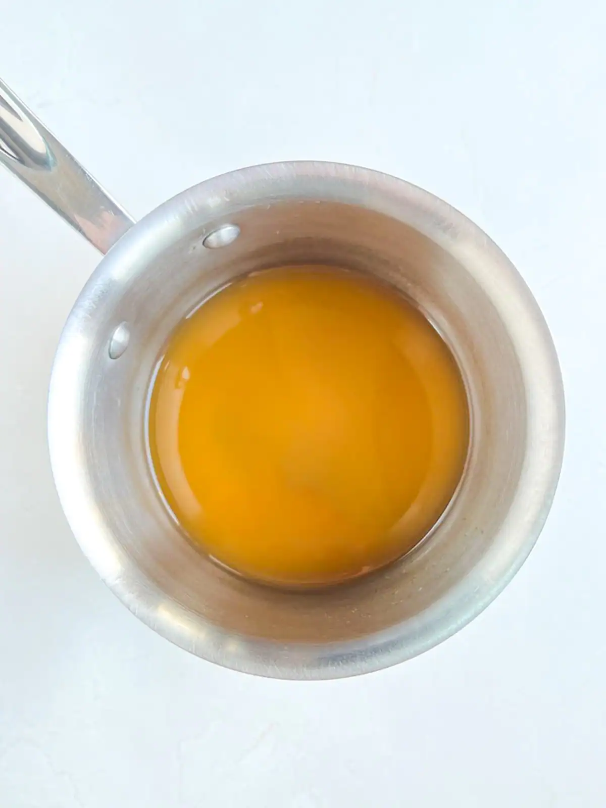 White wine and vegetable broth in a stainless steel pot.