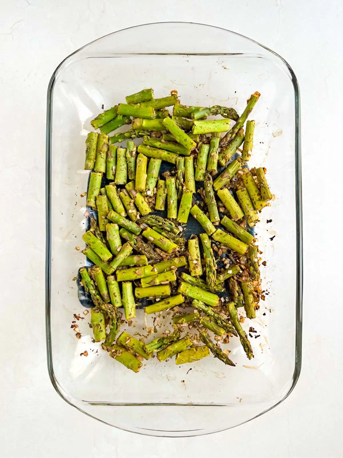 Roasted asparagus in glass casserole dish.